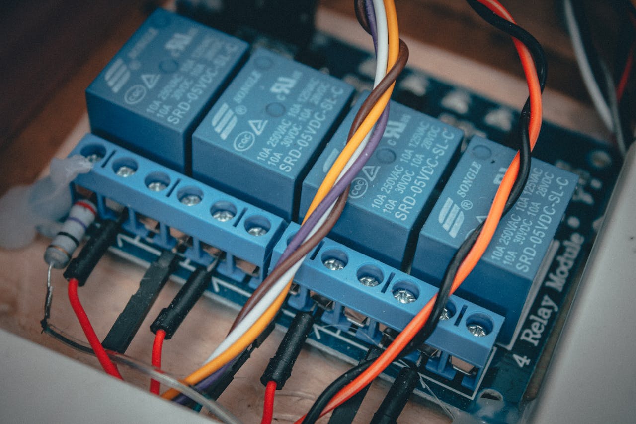 services-04 Blue relay modules with colorful wires connected on an electronic board.
